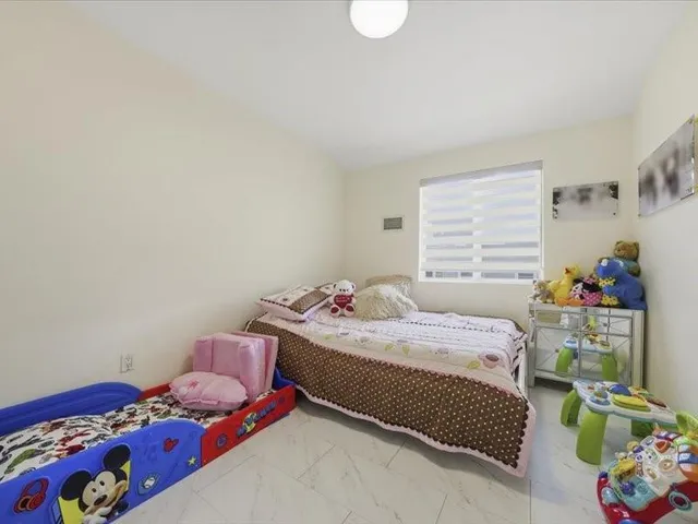 a bedroom with furniture and a painting on the wall
