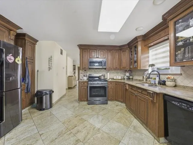 a kitchen with stainless steel appliances granite countertop a stove sink and refrigerator