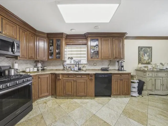 a kitchen with stainless steel appliances granite countertop a stove sink and cabinets