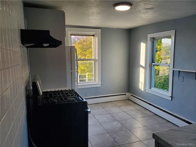 a kitchen with a black white stove top oven and a dishwasher next to a window