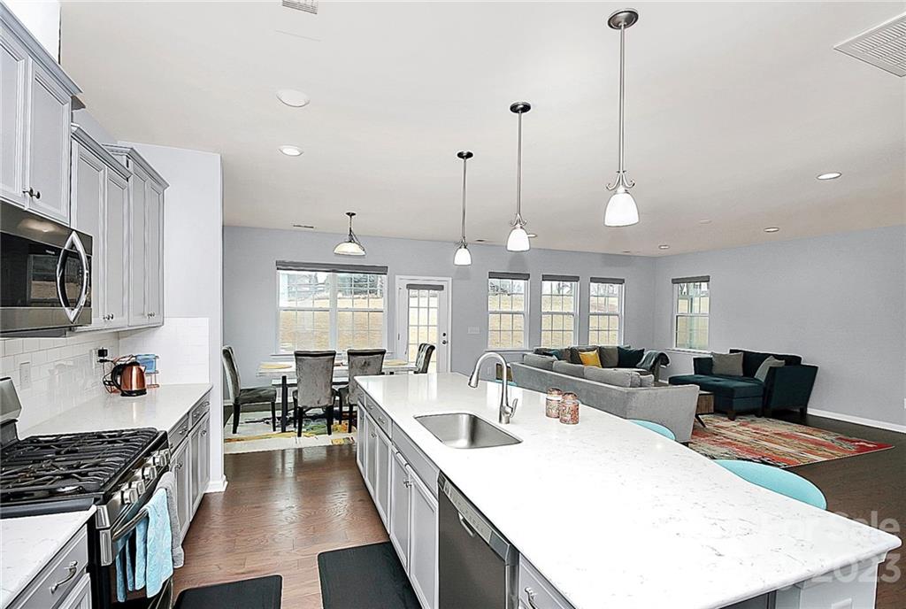 227 Houston Blair Road Matthews, NC 28104 - Photo 16 of 39 a large kitchen with lots of counter space dining table and stainless steel appliances