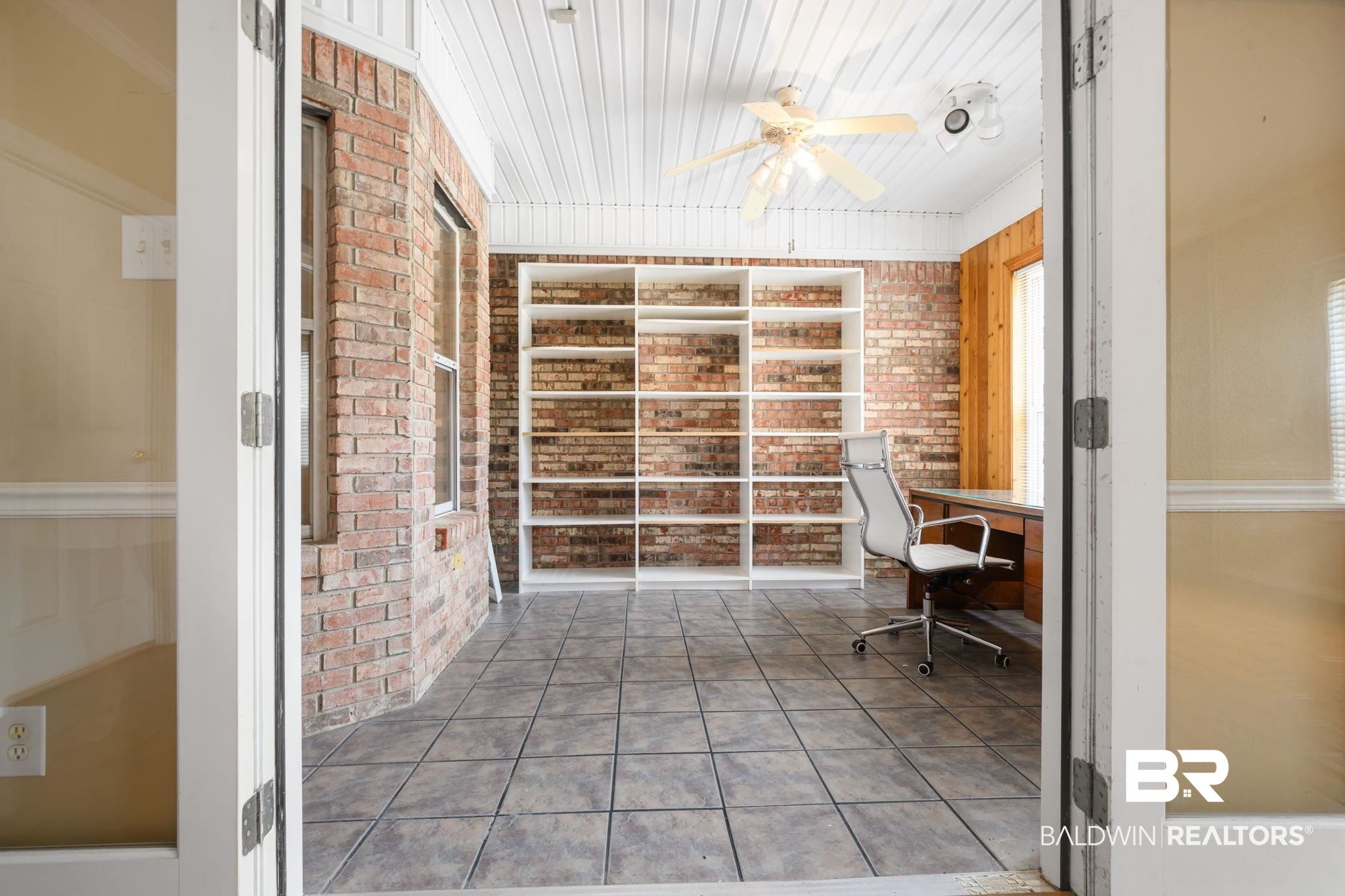 7540 2 Mile Road Irvington, AL 36544 - Photo 40 of 82 Interior space featuring exposed brick walls, tile flooring, and a white beadboard ceiling with a ceiling fan