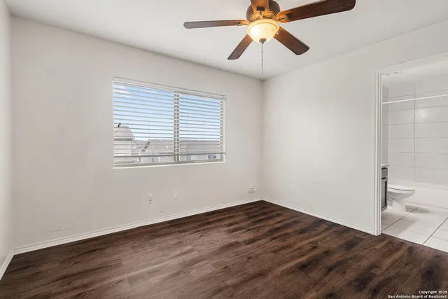 a view of a room with wooden floor and fan