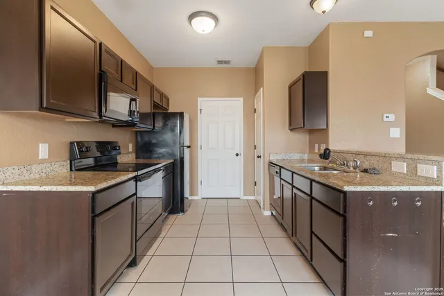 a kitchen with stainless steel appliances granite countertop a sink and cabinets