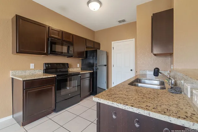 a kitchen with stainless steel appliances granite countertop a sink and a stove