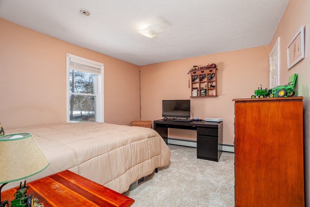 113 Parker Road, Unit 1 Lancaster, MA 01523 - Photo 19 of 30 a bedroom with a bed and a flat screen tv