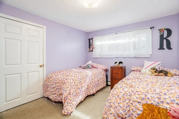 a bedroom with two beds and painting on the wall
