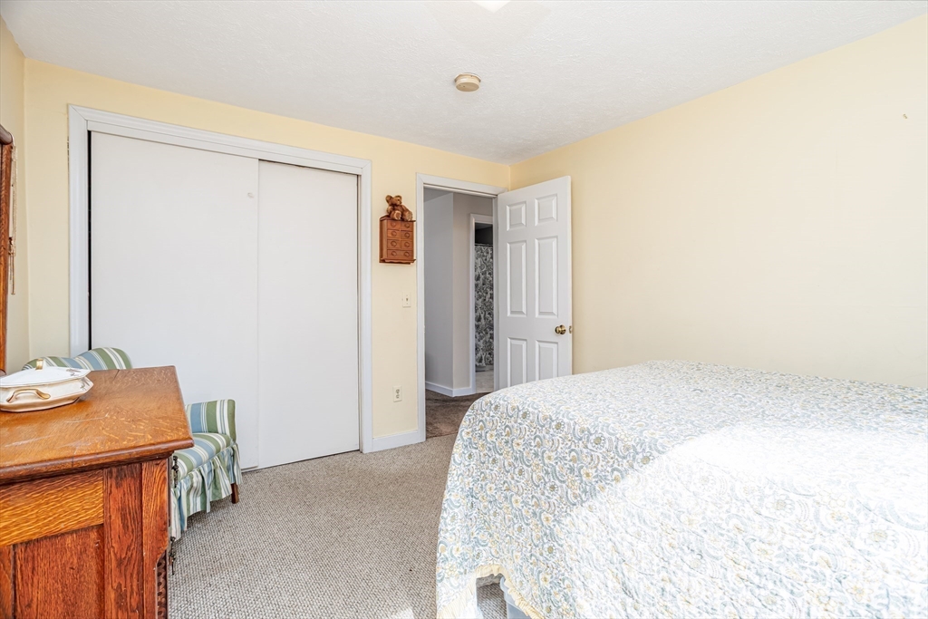 113 Parker Road, Unit 1 Lancaster, MA 01523 - Photo 27 of 30 a spacious bedroom with a bed and a table in it