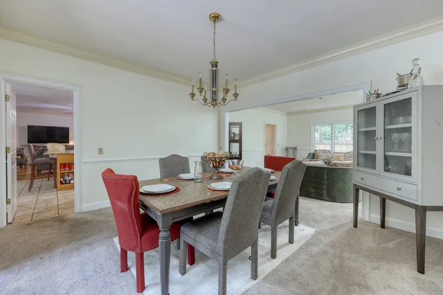 a kitchen with stainless steel appliances granite countertop table chairs and chandelier
