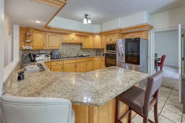 a kitchen with granite countertop cabinets stainless steel appliances a sink and a counter top space