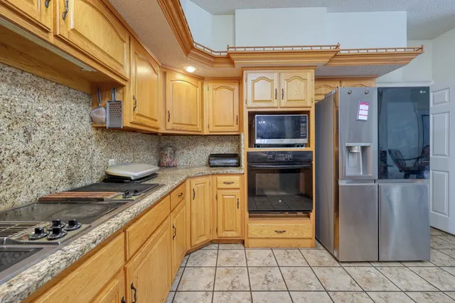 a kitchen with granite countertop a stove top oven microwave and cabinets