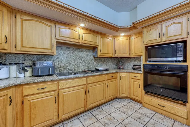 a large kitchen with kitchen island a sink counter space and chairs