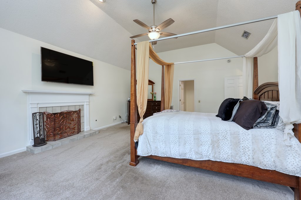 5135 Midland Trace Midland, GA 31820 - Photo 26 of 66 a spacious bedroom with a bed and a flat screen tv