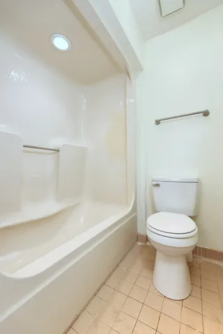 a spacious bedroom with a bed and a desk in it