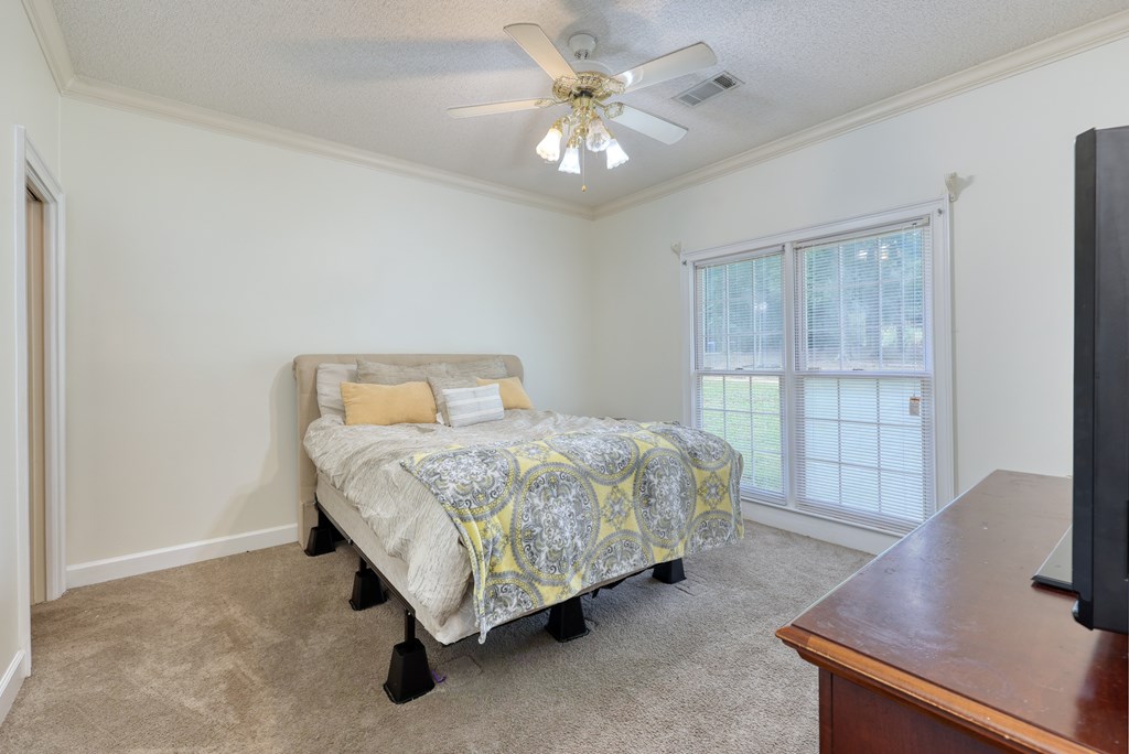 5135 Midland Trace Midland, GA 31820 - Photo 36 of 66 a spacious bedroom with a bed and a desk in it