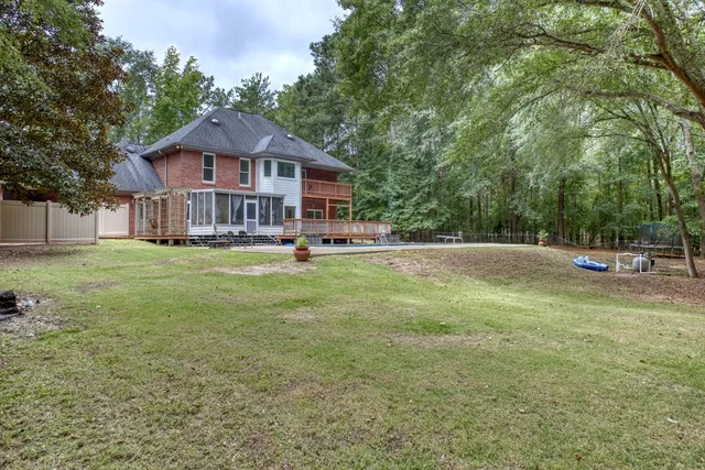 an aerial view of residential house with outdoor space and trees all around