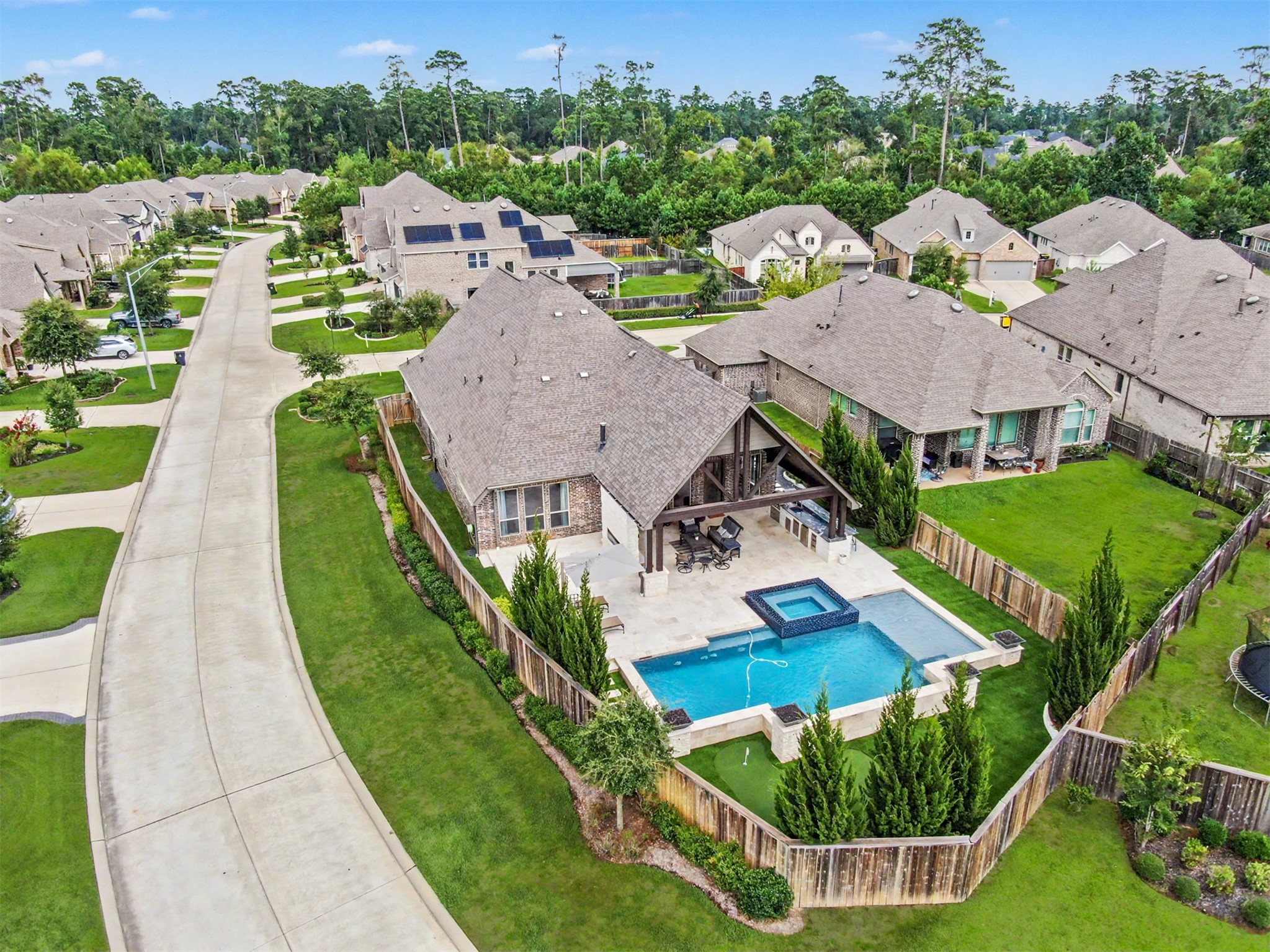 343 Torrey Bloom Loop Conroe, TX 77304 - Photo 3 of 49 Aerial view showcasing the home’s expansive corner lot and incredible resort-style backyard featuring a sparkling pool and raised spa, oversized covered pavilion, outdoor kitchen, extensive patio space, private putting green and lush landscaping.