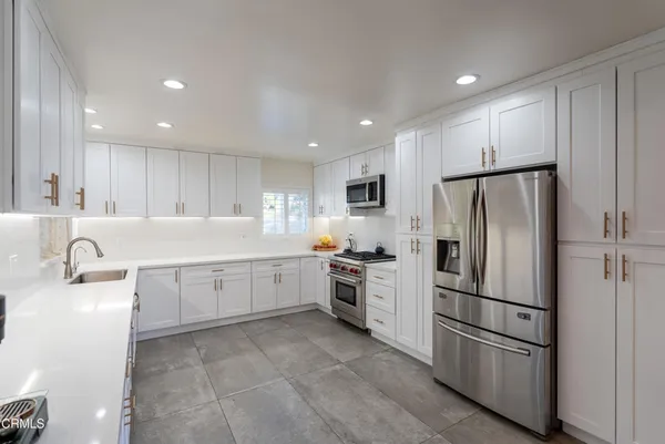 a kitchen with granite countertop stainless steel appliances and refrigerator