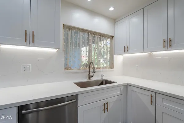 a view of a kitchen with a sink and large window