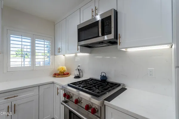 a kitchen with stainless steel appliances a stove a microwave and cabinets