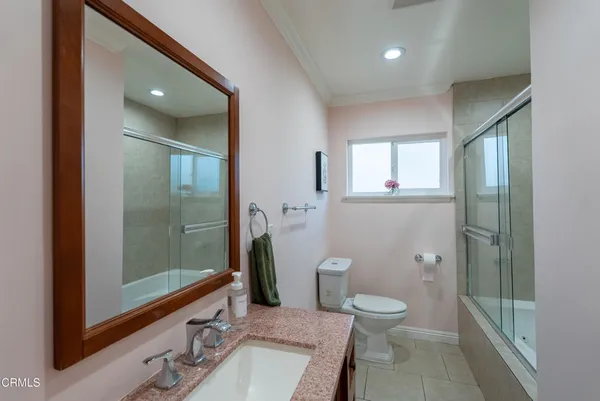a bathroom with a toilet a sink and glass door