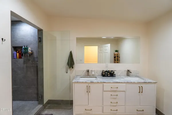 a bathroom with a granite countertop sink and a mirror