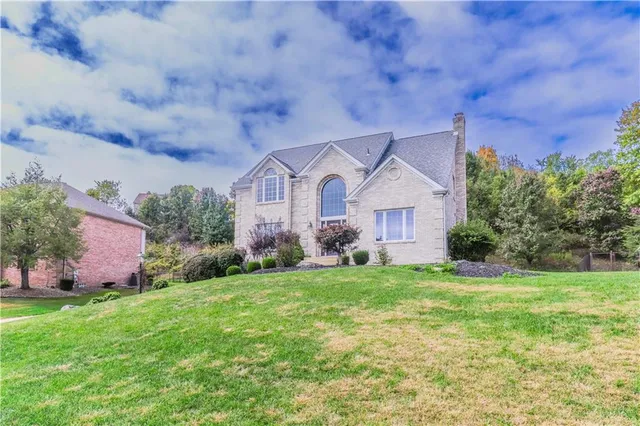 a front view of a house with a garden and trees