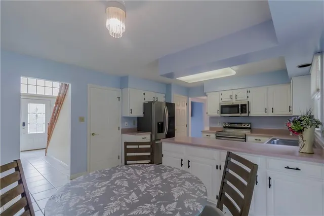 a kitchen with a dining table chairs and refrigerator