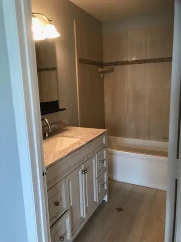 a bathroom with a granite countertop sink and a mirror