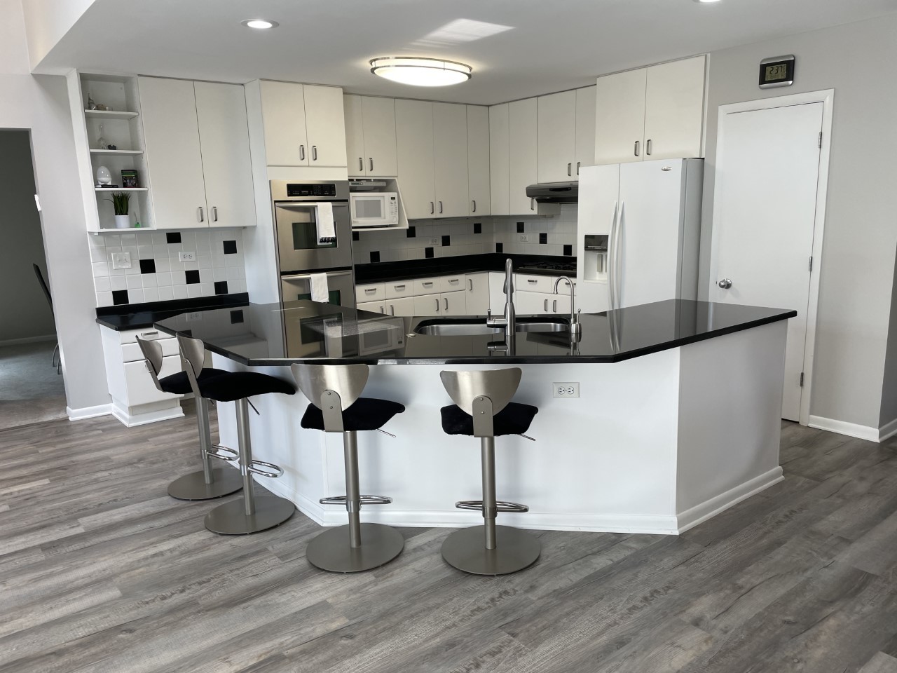 1958 McCraren Road Highland Park, IL 60035 - Photo 12 of 23 a kitchen with stainless steel appliances kitchen island granite countertop a dining table chairs and granite counter tops