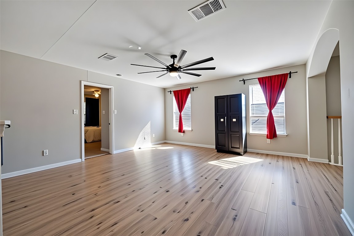 350 Carriage Way Kyle, TX 78640 - Photo 21 of 37 an empty room with wooden floor ceiling fan and windows