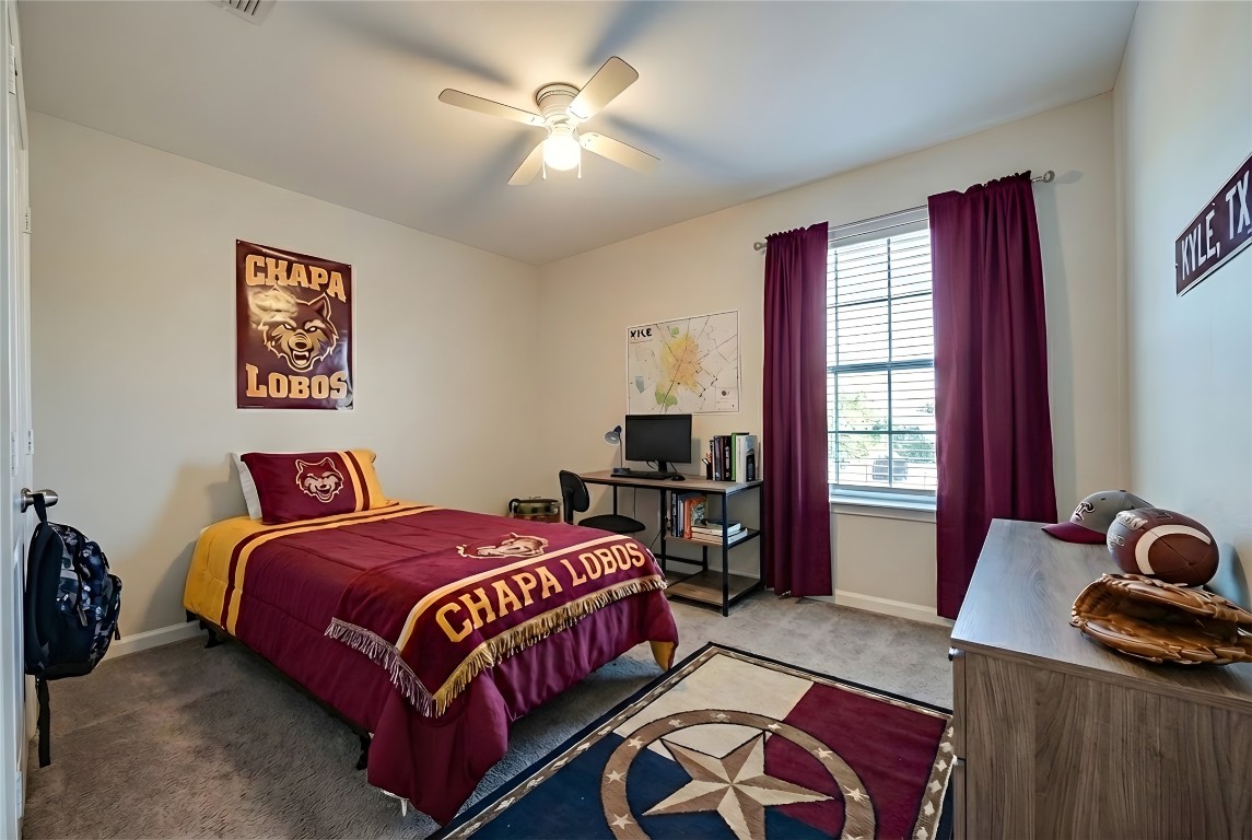 350 Carriage Way Kyle, TX 78640 - Photo 26 of 37 a bedroom with a bed and a chandelier