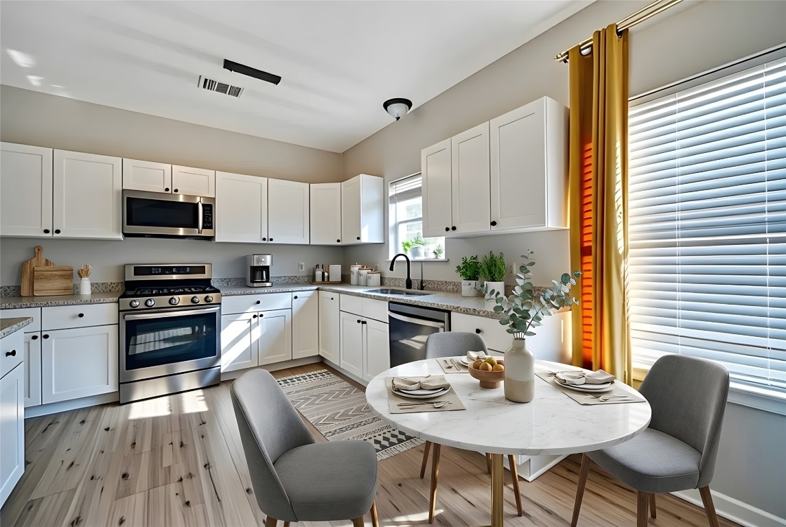 350 Carriage Way Kyle, TX 78640 - Photo 6 of 37 a kitchen with stainless steel appliances granite countertop a stove a sink dishwasher a stove a refrigerator with a dining table and chairs