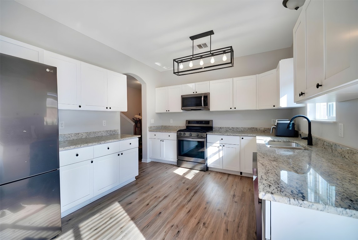 350 Carriage Way Kyle, TX 78640 - Photo 7 of 37 a kitchen with granite countertop a stove top oven a sink a counter space and cabinets