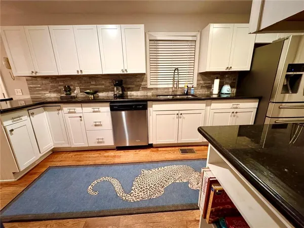 a kitchen with stainless steel appliances granite countertop a sink stove and cabinets