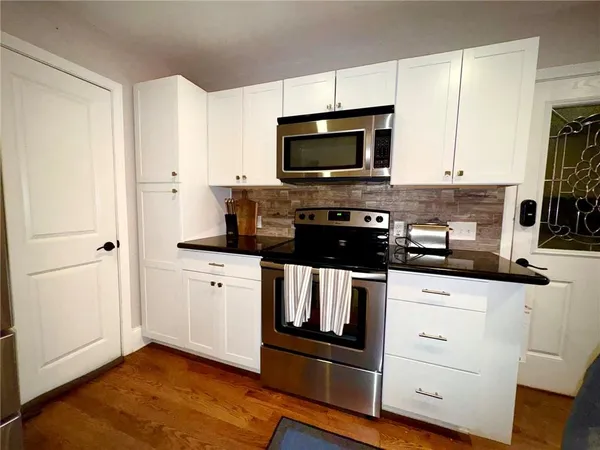 a kitchen with white cabinets stainless steel appliances and sink
