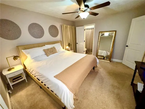 a bedroom with a bed and a mirror on the dresser