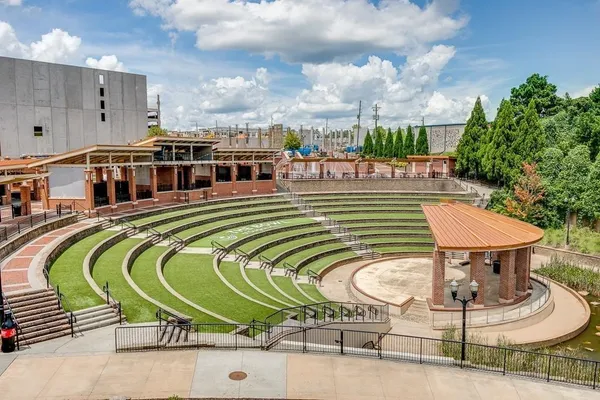 a pathway of a house with potted plants and a bench