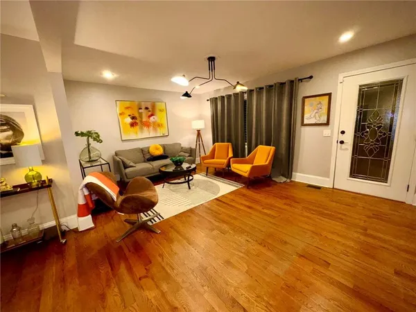 a living room with furniture and a wooden floor