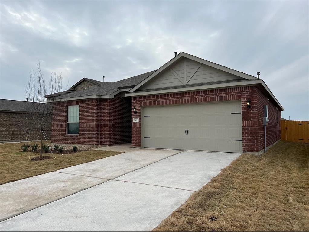 2013 Emma Court Anna, TX 75409 - Photo 2 of 20 Brick exterior featuring a two-car garage with carriage-style hardware