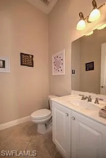 a bathroom with a granite countertop sink mirror vanity and toilet