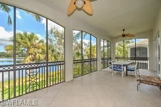 a dining room with furniture large windows and a chandelier