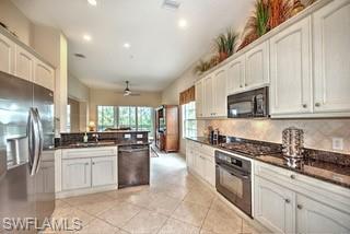 9255 Museo Circle, Unit 204 Naples, FL 34114 - Photo 6 of 27 a kitchen with stainless steel appliances granite countertop a stove a sink a refrigerator and white cabinets