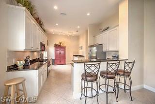9255 Museo Circle, Unit 204 Naples, FL 34114 - Photo 8 of 27 a kitchen with a table chairs stove and cabinets