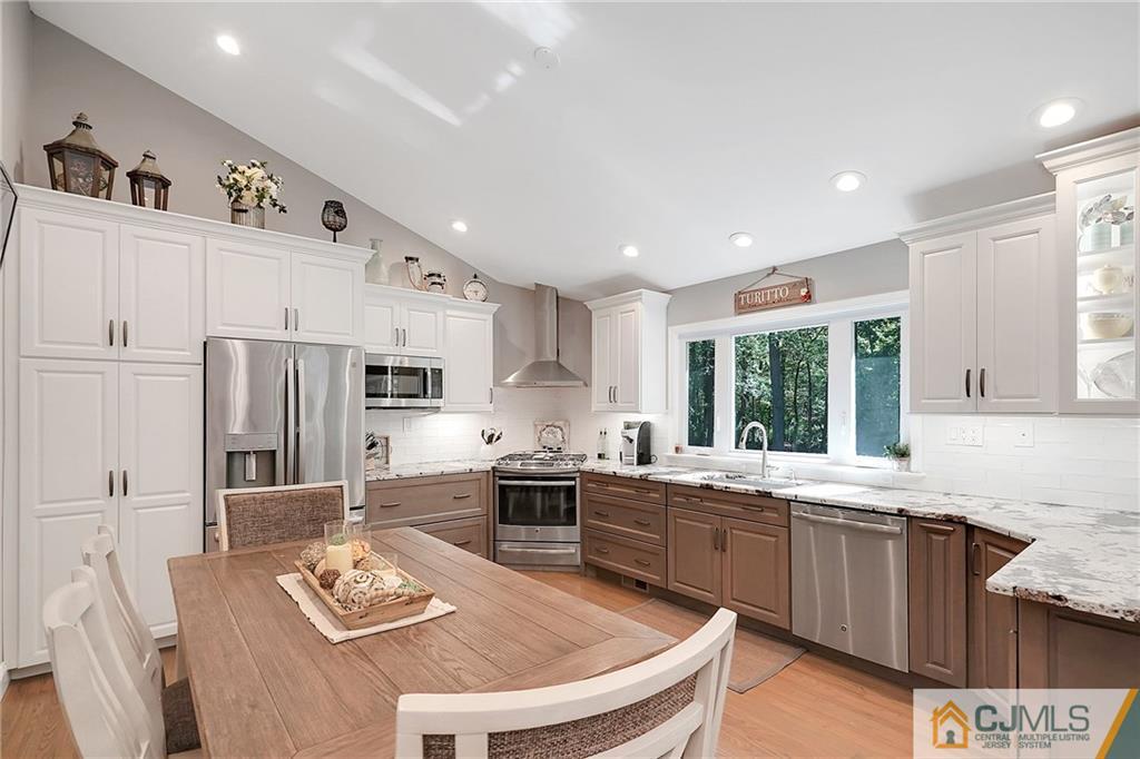 97 Rieder Road Spotswood, NJ 08884 - Photo 13 of 37 a kitchen with stainless steel appliances kitchen island granite countertop a sink dishwasher stove and refrigerator with wooden floor