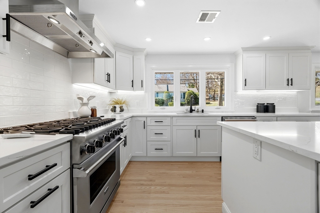 171 Shaw Road Brookline, MA 02467 - Photo 5 of 42 a kitchen with white cabinets and stainless steel appliances