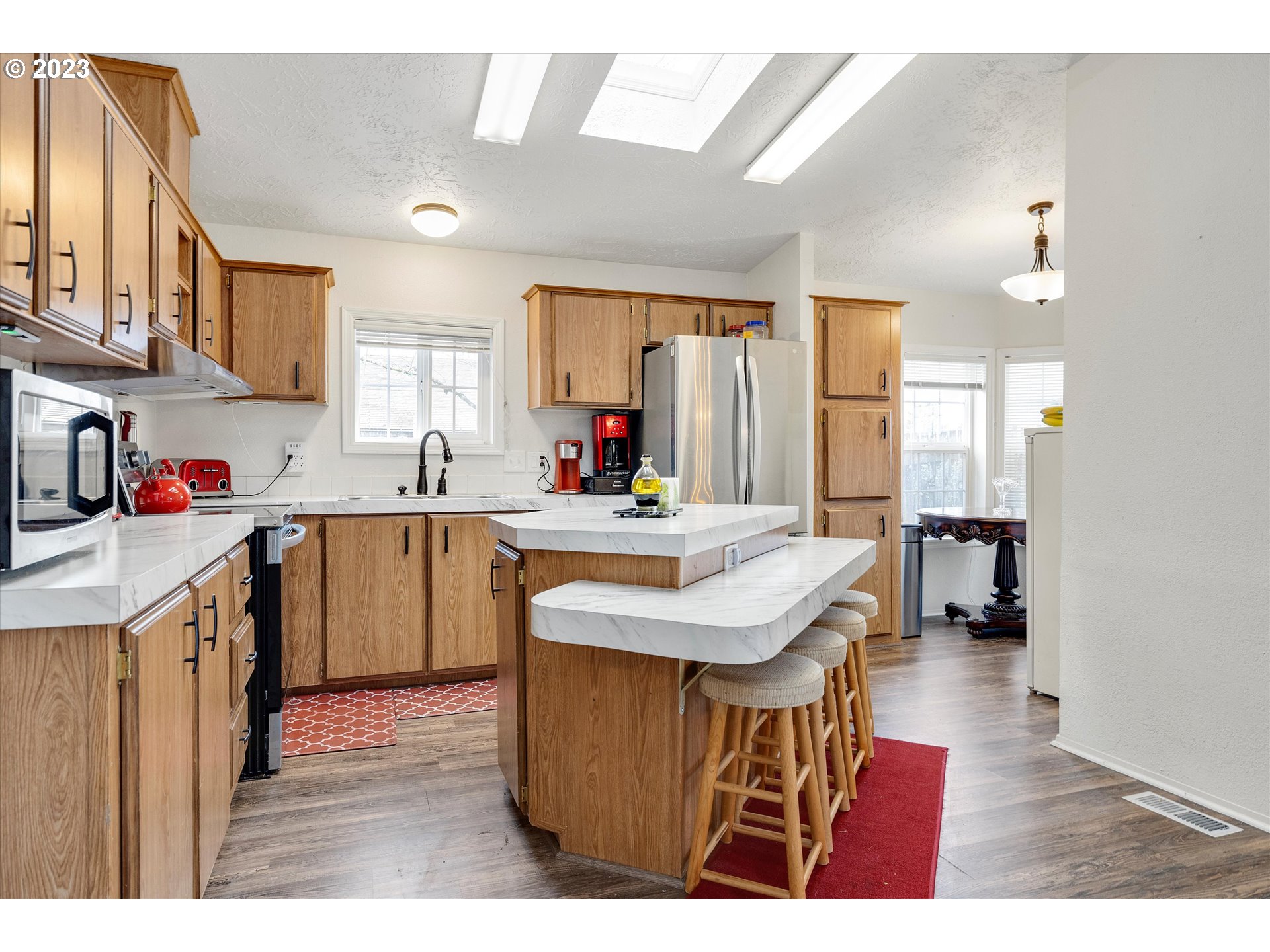 1949 Southeast Palmquist Road, Unit 17 Gresham, OR 97080 - Photo 12 of 31 a kitchen with kitchen island granite countertop a sink a counter top space and stainless steel appliances