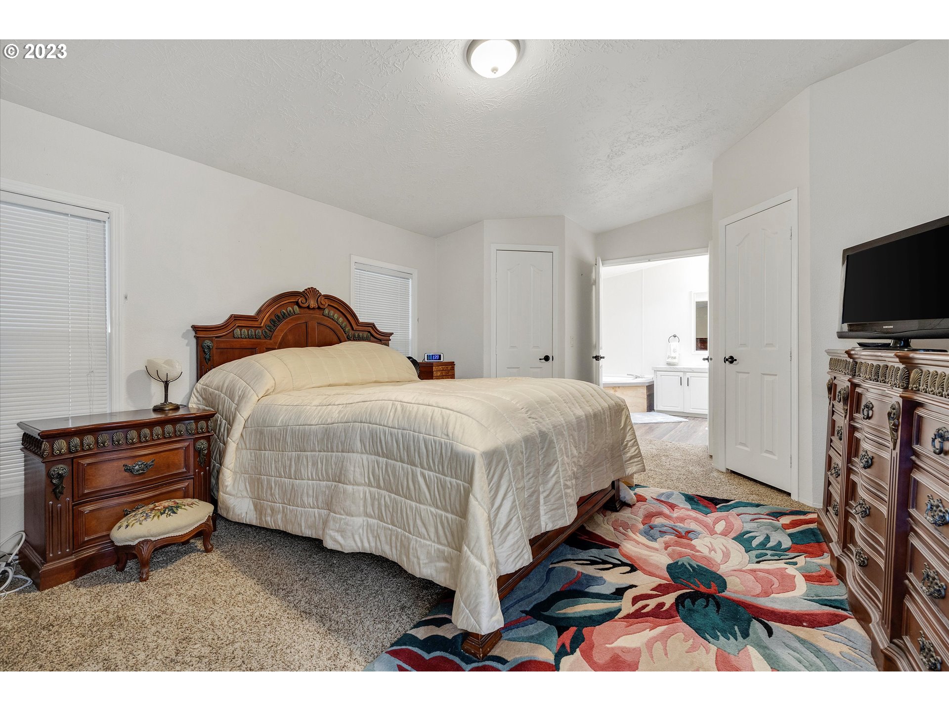1949 Southeast Palmquist Road, Unit 17 Gresham, OR 97080 - Photo 16 of 31 a bedroom with a bed and a flat screen tv