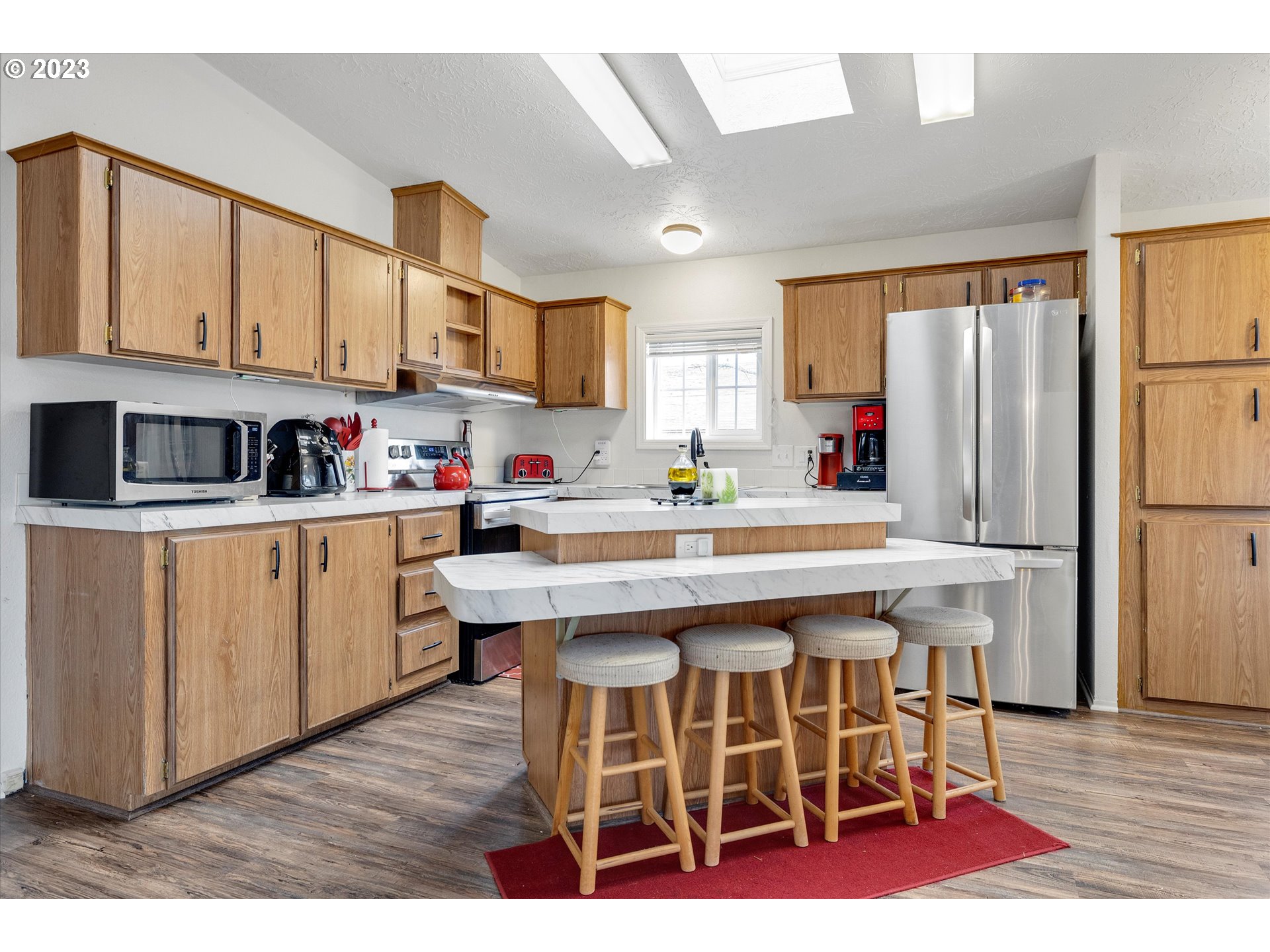 1949 Southeast Palmquist Road, Unit 17 Gresham, OR 97080 - Photo 10 of 31 a kitchen with stainless steel appliances kitchen island granite countertop a table chairs sink and cabinets