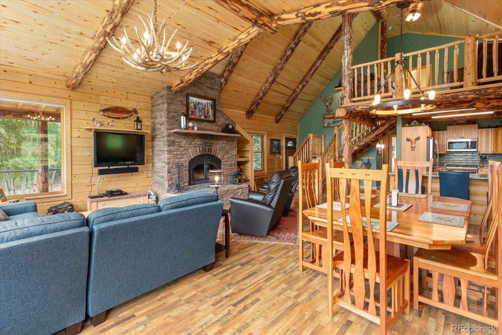 1021 Silver Lakes Road Villa Grove, CO 81155 - Photo 12 of 50 a living room with furniture a flat screen tv and a floor to ceiling window
